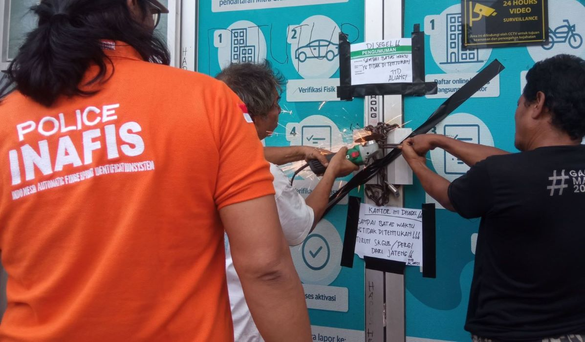 Aplikator dan petugas Polrestabes Semarang membuka segel kantor Grab dan Maxim di Semarang. 